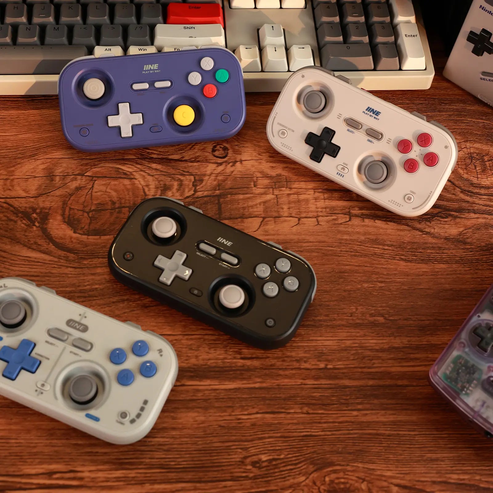 Collection of IINE palm-sized controllers on a wooden gaming desk