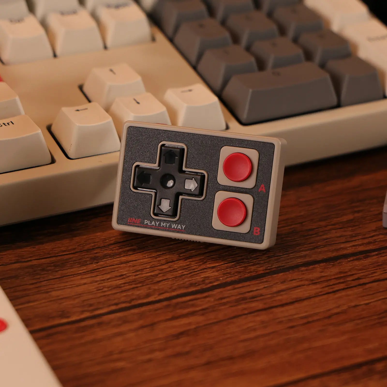 Gray IINE GameBrick Mini controller photographed beside a keyboard